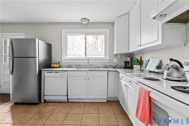 a kitchen with a refrigerator sink and cabinets