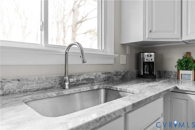 a kitchen with granite countertop a sink and a window