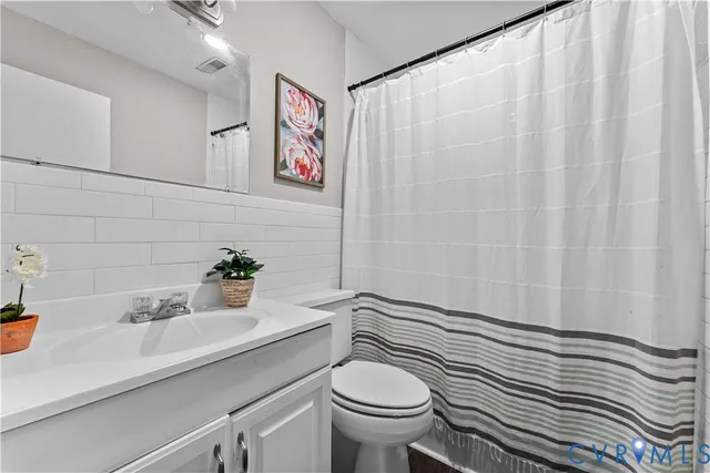 a bathroom with a sink a toilet and shower curtain