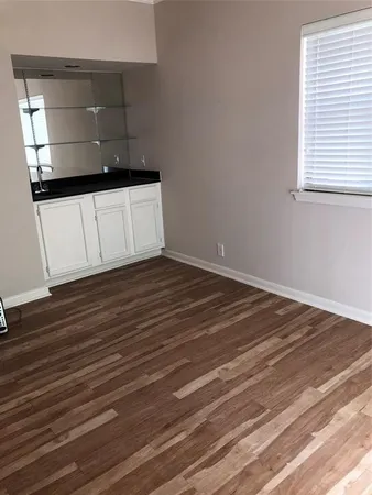 a view of a hallway with wooden floor and a cabinet