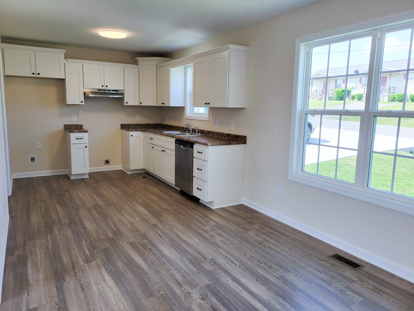 62 Modena Place Decherd, TN 37324 - Photo 9 of 31 a kitchen with granite countertop wooden floors white cabinets and wooden floors