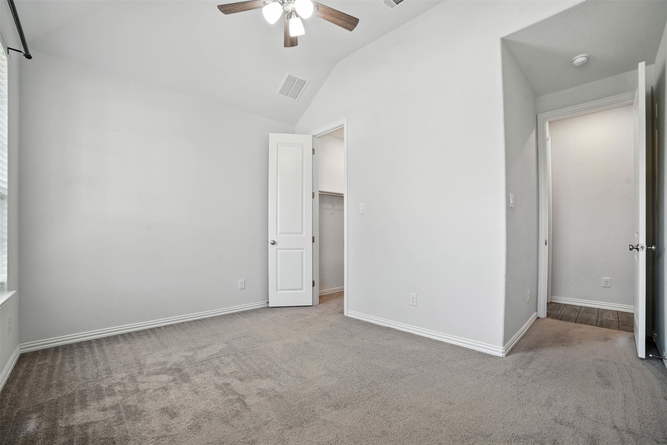 3054 Columbus Loop Round Rock, TX 78665 - Photo 12 of 40 Unfurnished bedroom featuring carpet floors, lofted ceiling, a walk in closet, and ceiling fan