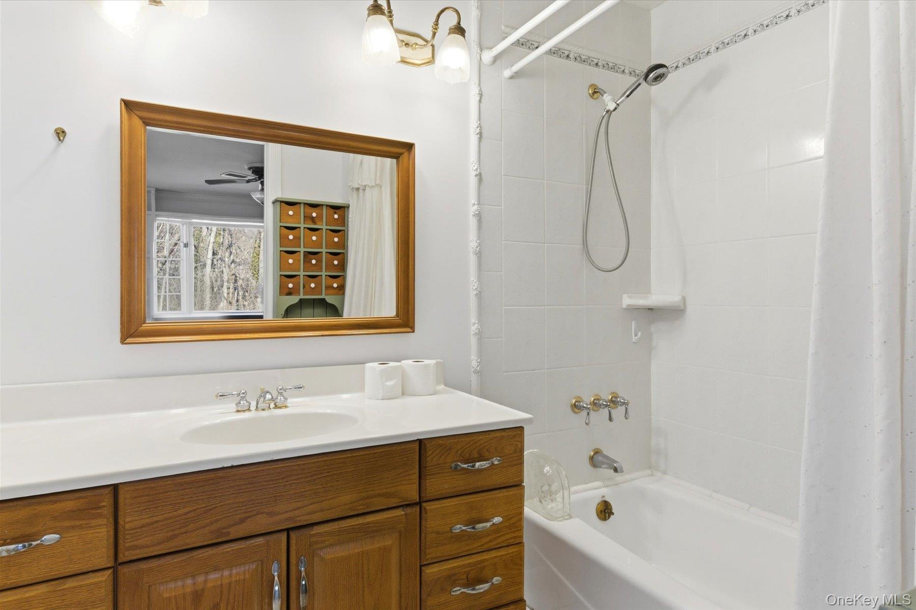 45 Eastwood Road Miller Place, NY 11764 - Photo 11 of 45 a bathroom with a tub sink shower and mirror