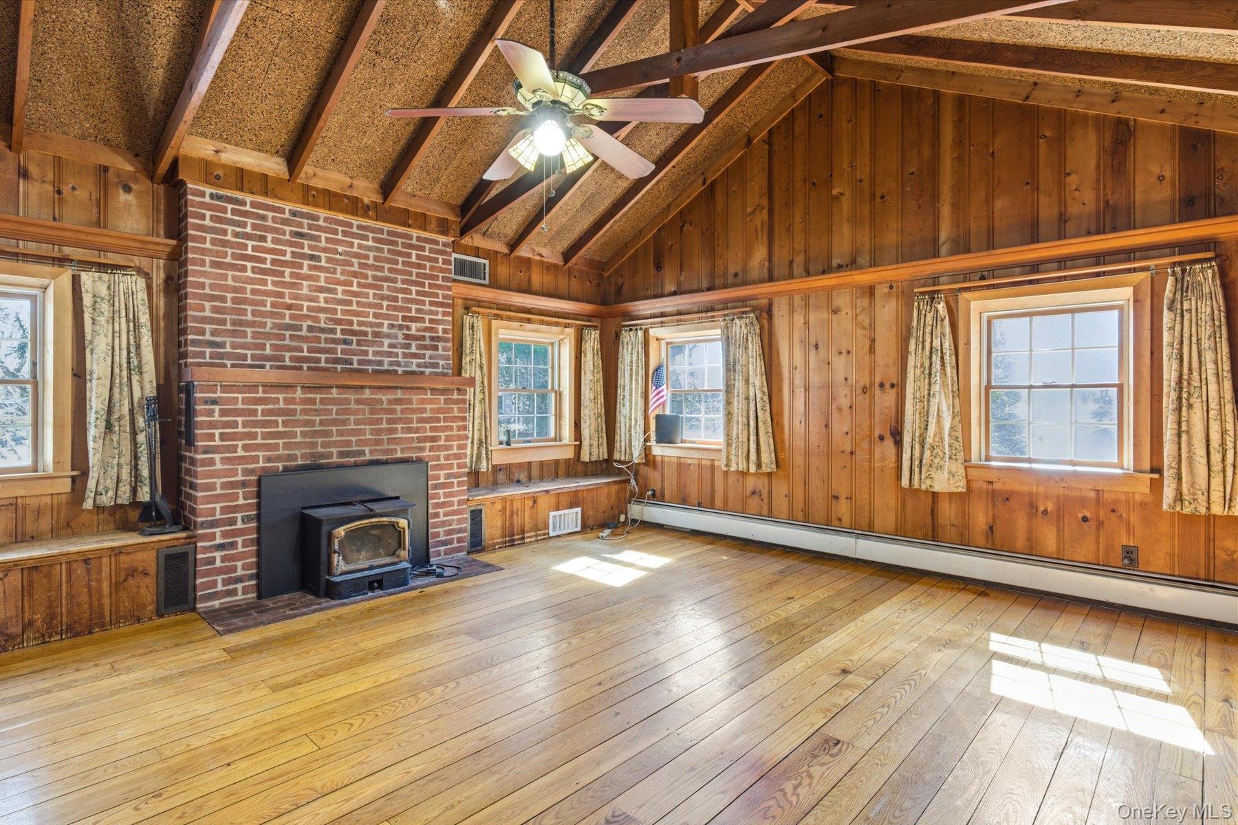 45 Eastwood Road Miller Place, NY 11764 - Photo 13 of 45 a view of an empty room with wooden floor fireplace and a window