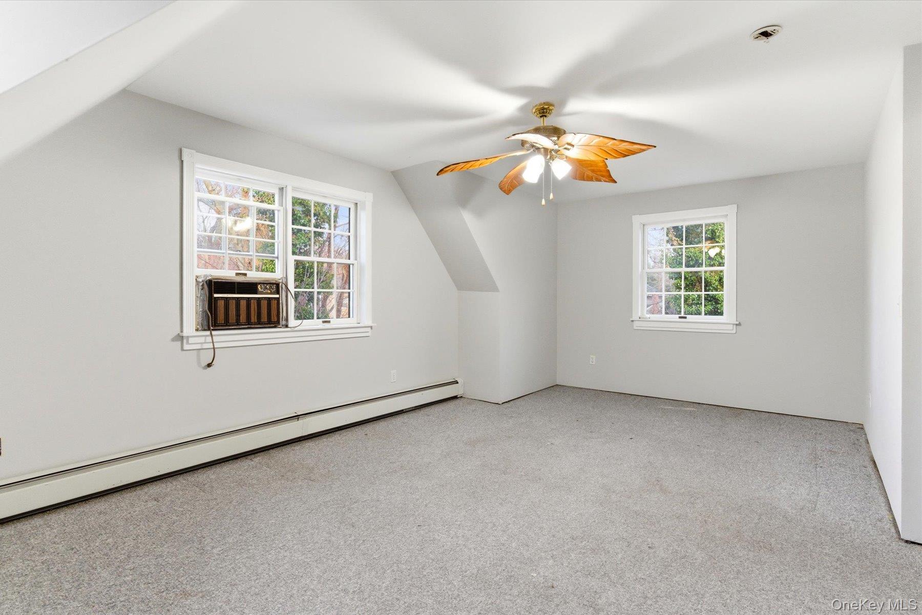 45 Eastwood Road Miller Place, NY 11764 - Photo 25 of 45 an empty room with windows and chandelier fan