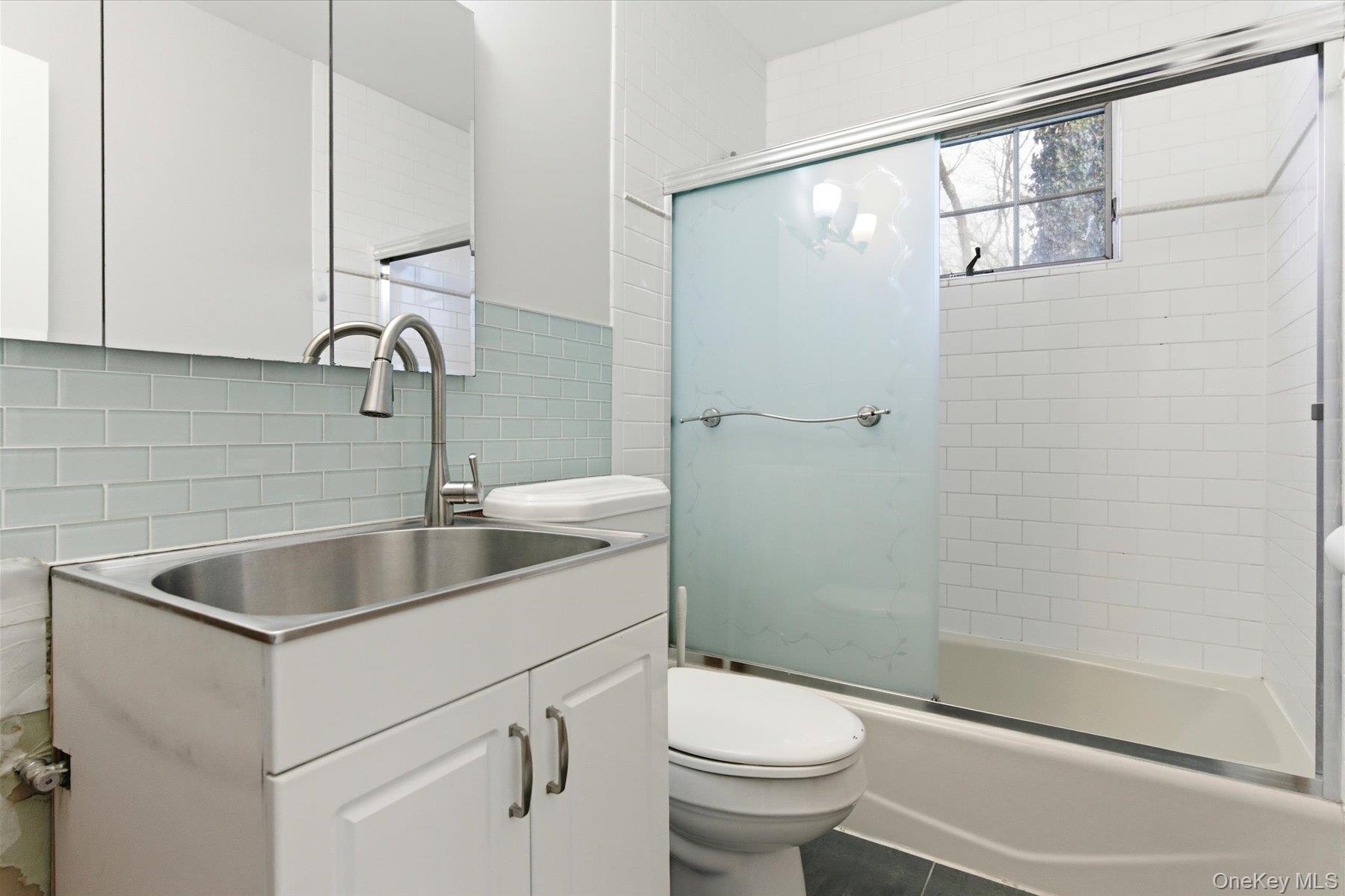 45 Eastwood Road Miller Place, NY 11764 - Photo 26 of 45 a bathroom with a sink a toilet and shower