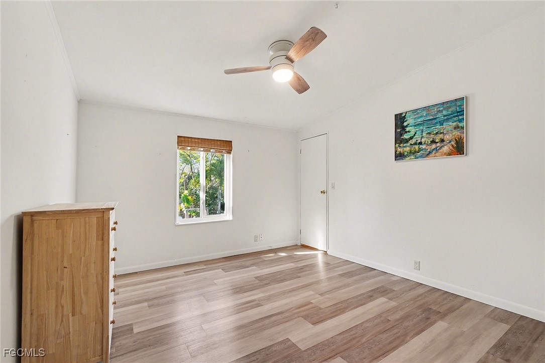 5228 Stringfellow Road St. James City, FL 33956 - Photo 11 of 35 a view of an empty room with wooden floor and a window