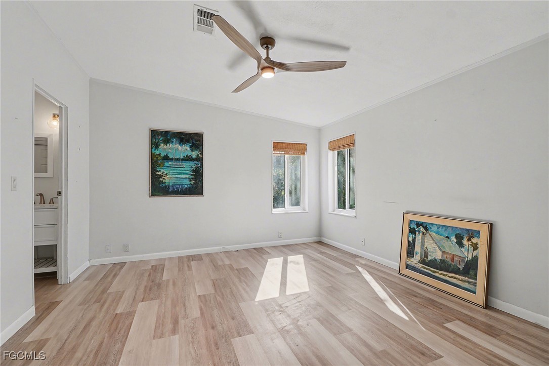5228 Stringfellow Road St. James City, FL 33956 - Photo 13 of 35 a view of empty room with wooden floor and window