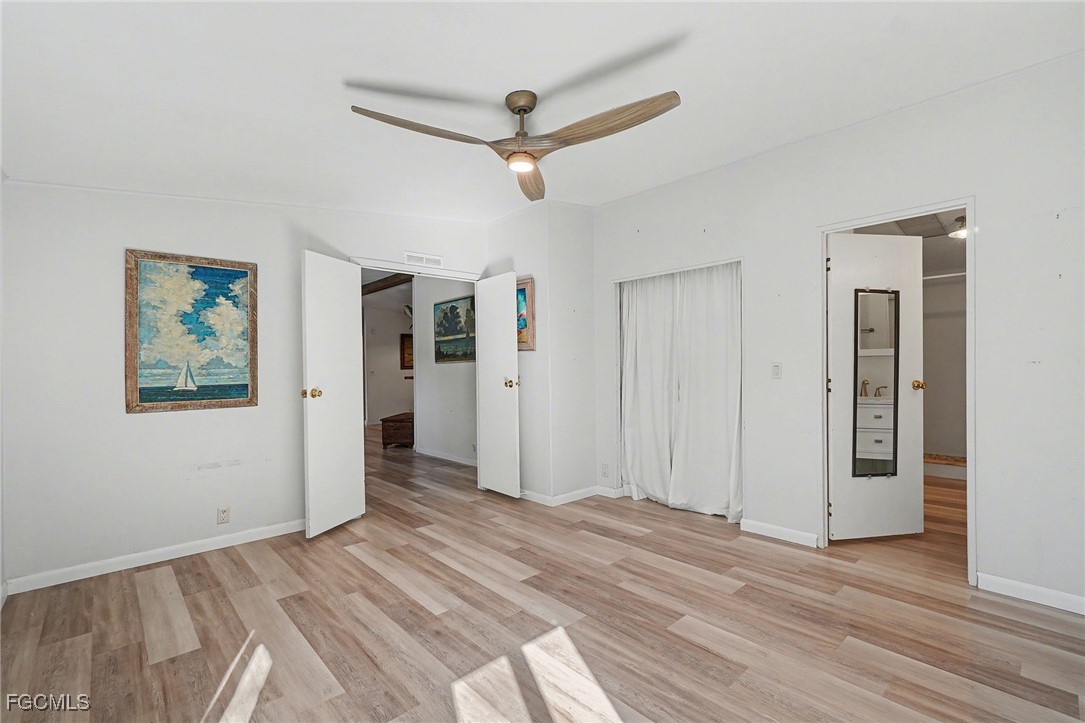 5228 Stringfellow Road St. James City, FL 33956 - Photo 14 of 35 a view of a livingroom with wooden floor and a ceiling fan