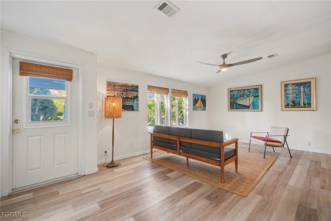 5228 Stringfellow Road St. James City, FL 33956 - Photo 4 of 35 a living room with furniture and a wooden floor