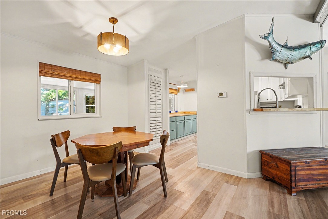 5228 Stringfellow Road St. James City, FL 33956 - Photo 6 of 35 a dining room with wooden floor and a chandelier