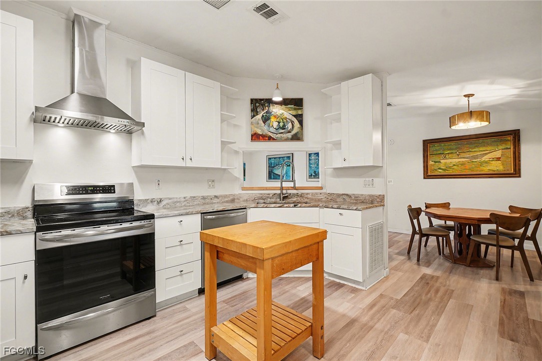 5228 Stringfellow Road St. James City, FL 33956 - Photo 10 of 35 a kitchen with a stove a refrigerator and a dining table