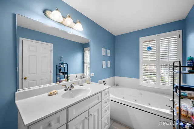 a bathroom with a sink a large mirror and a bathtub