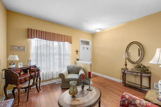 a living room with furniture a window and wooden floor