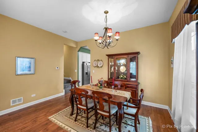 a view of a dining room with furniture and chandelier