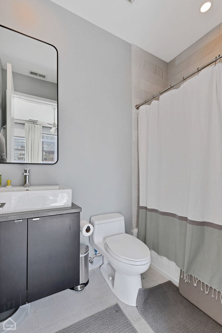 155 North Aberdeen Street, Unit 304 Chicago, IL 60607 - Photo 20 of 33 a bathroom with a toilet a sink and mirror
