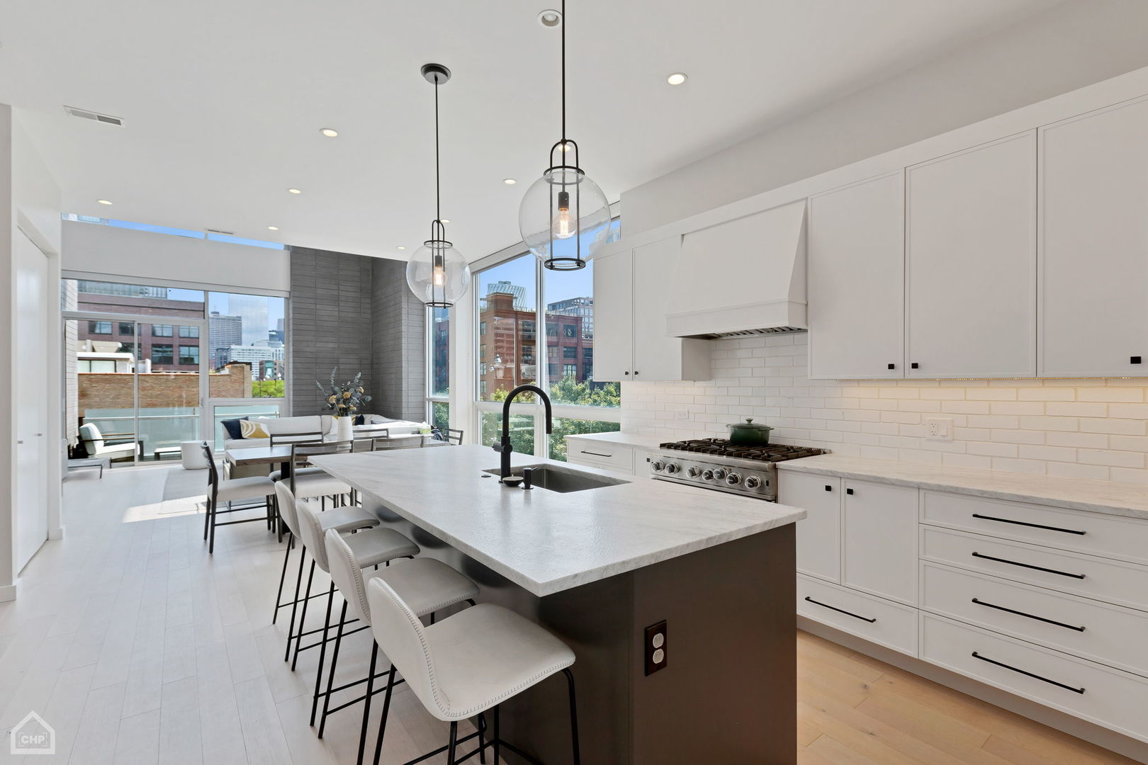 155 North Aberdeen Street, Unit 304 Chicago, IL 60607 - Photo 10 of 33 a kitchen with a sink stove and white cabinets with wooden floor