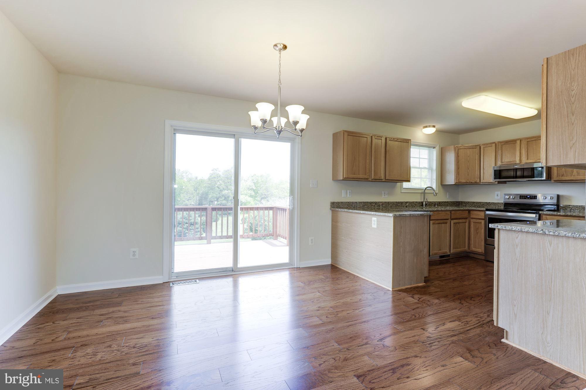 14065 Micah Road Rixeyville, VA 22737 - Photo 10 of 40 a kitchen with granite countertop a stove a sink dishwasher a refrigerator and white cabinets with wooden floor