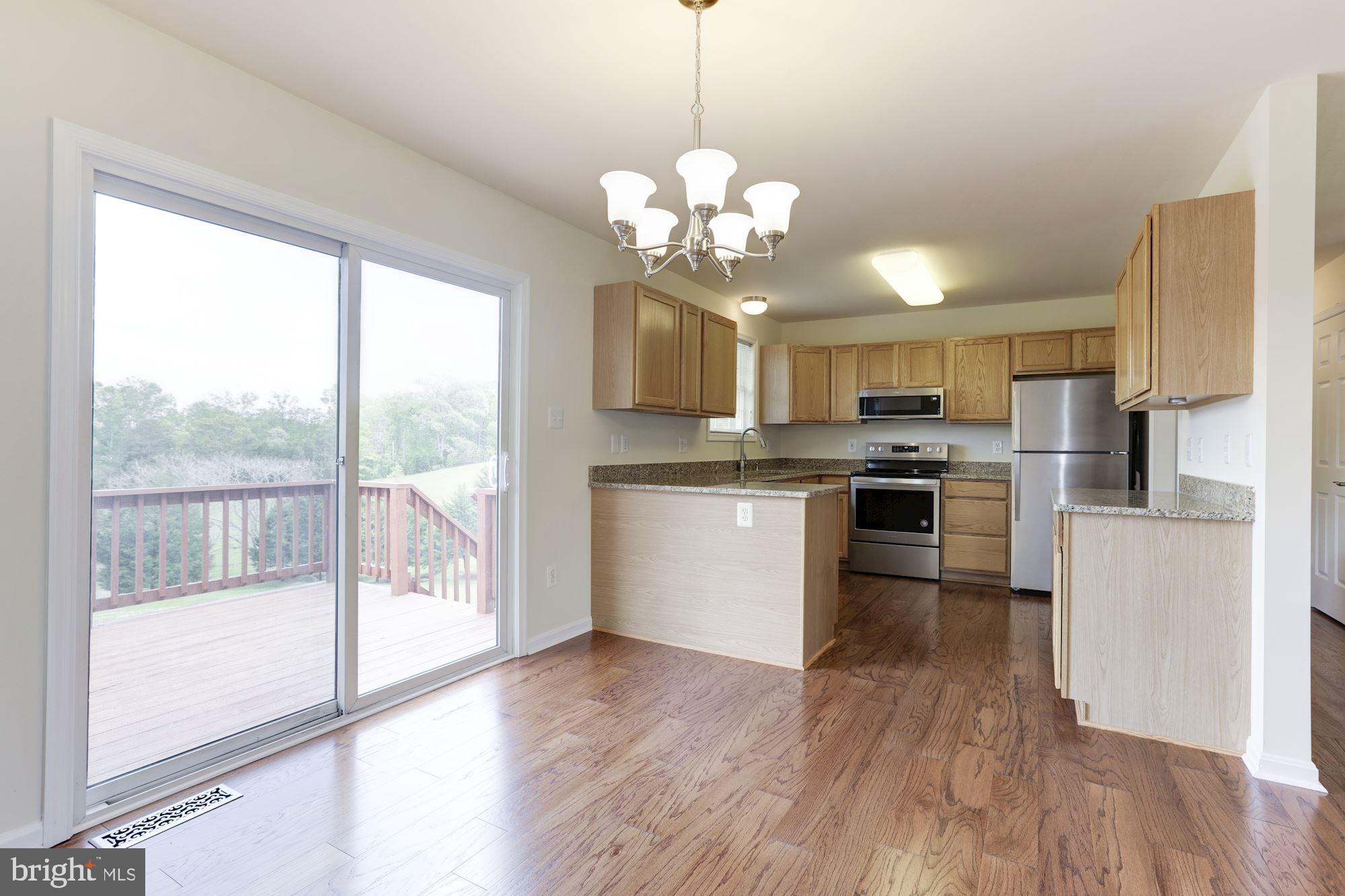 14065 Micah Road Rixeyville, VA 22737 - Photo 11 of 40 a kitchen with stainless steel appliances granite countertop a stove a refrigerator a sink and a wooden floor