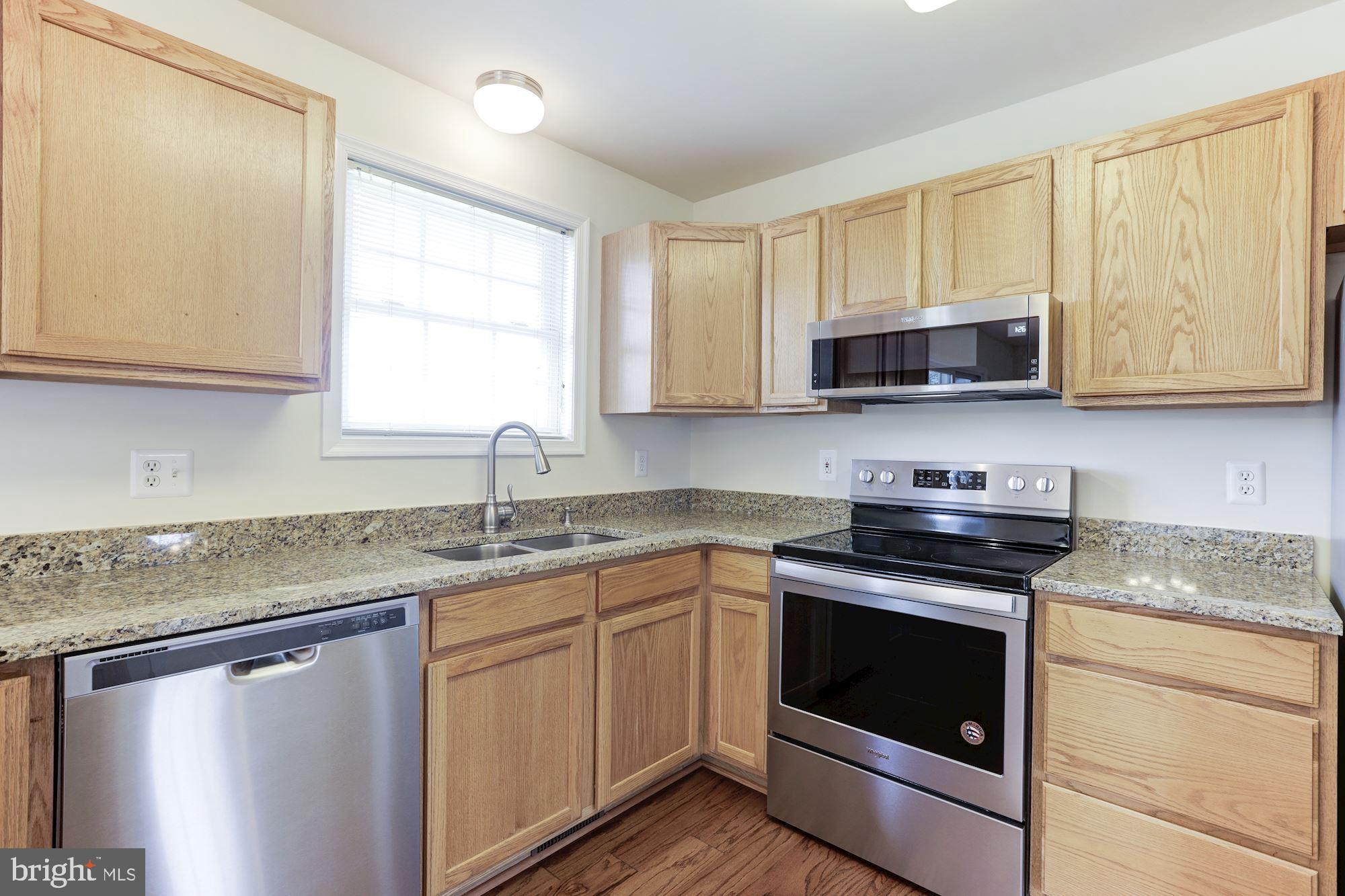 14065 Micah Road Rixeyville, VA 22737 - Photo 15 of 40 a kitchen with stainless steel appliances granite countertop a sink stove microwave and refrigerator