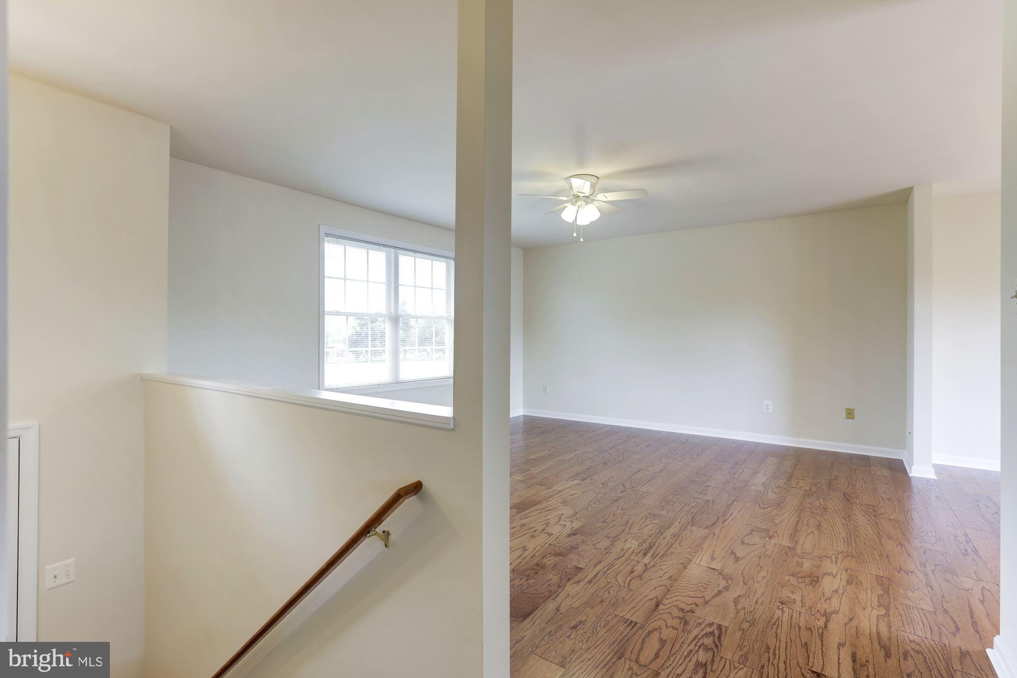 14065 Micah Road Rixeyville, VA 22737 - Photo 6 of 40 an empty room with wooden floor fan and windows