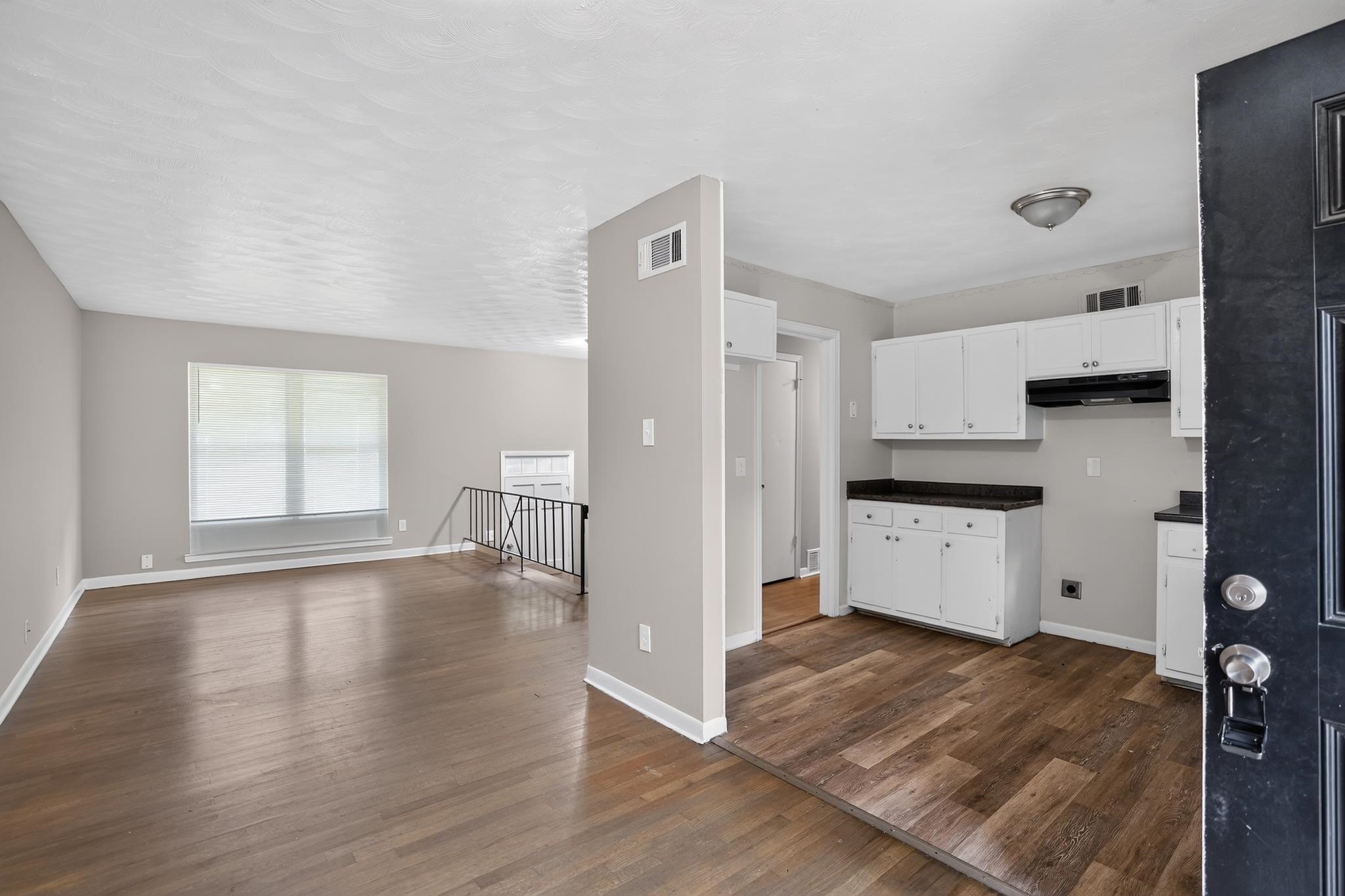 3391 South Perkins Road Memphis, TN 38118 - Photo 9 of 16 Wood-finish flooring throughout, white baseboards, and light gray wall paint