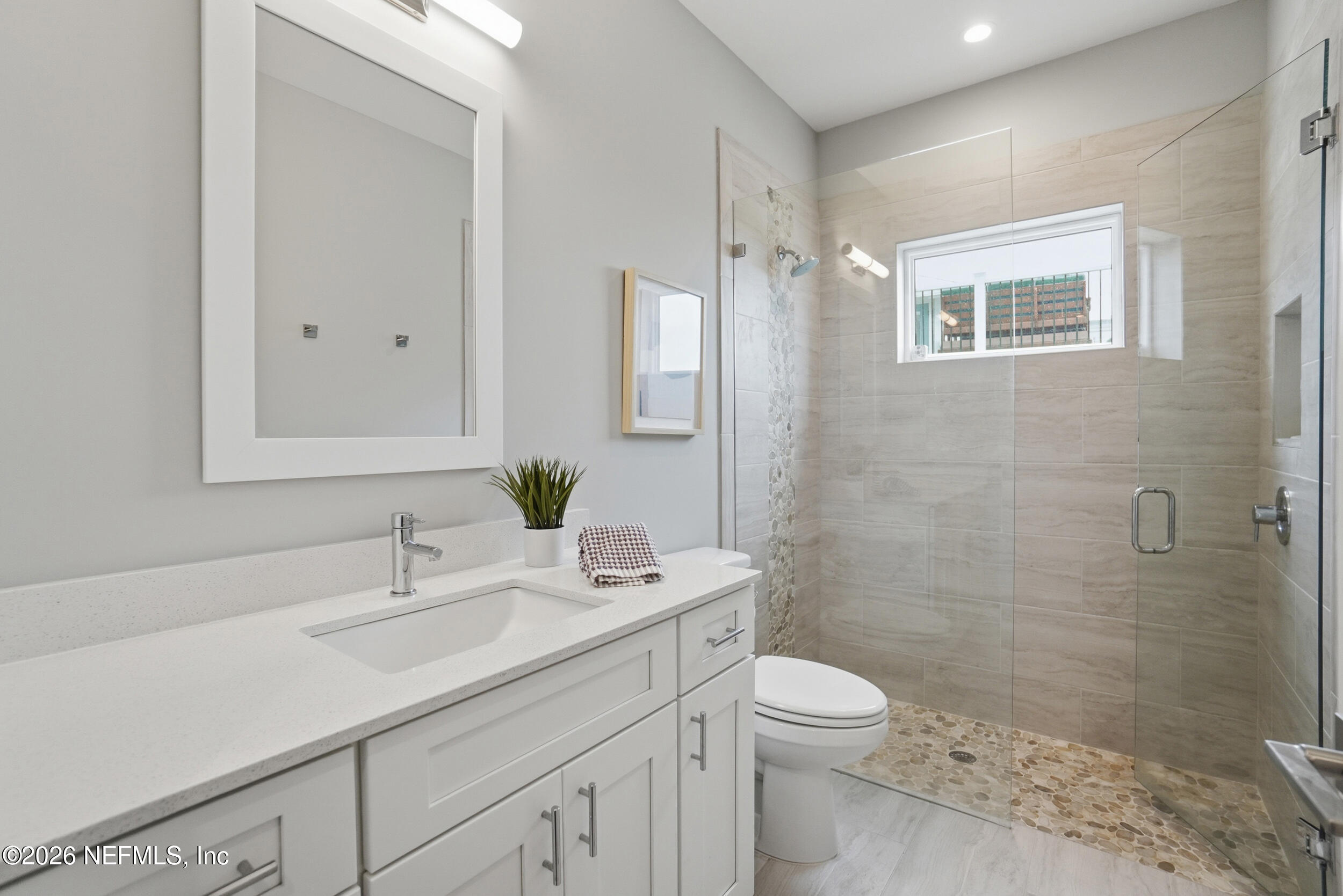 1717 Strand Street Neptune Beach, FL 32266 - Photo 45 of 84 a bathroom with a granite countertop toilet a sink a mirror a shower a vanity and window