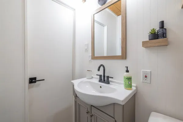 a bathroom with a sink toilet and mirror