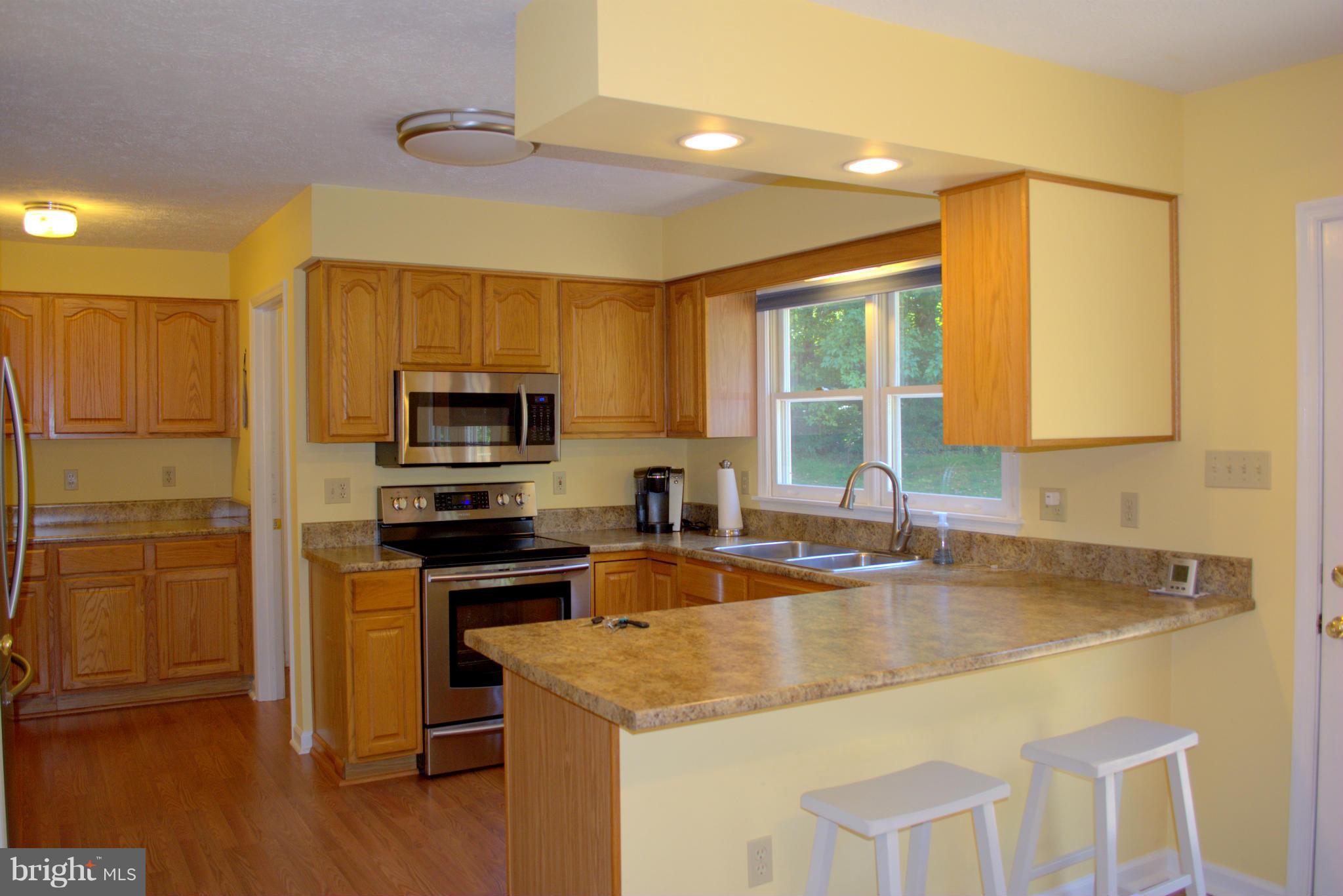 310 High Knob Road Front Royal, VA 22630 - Photo 2 of 30 a kitchen with granite countertop a sink and a stove top oven with wooden floor