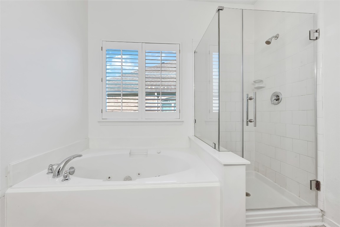 9606 Summer Run Houston, TX 77064 - Photo 20 of 41 Spa inspired primary bath featuring soaking tub with natural light, separate glass enclosed shower, and spacious layout.