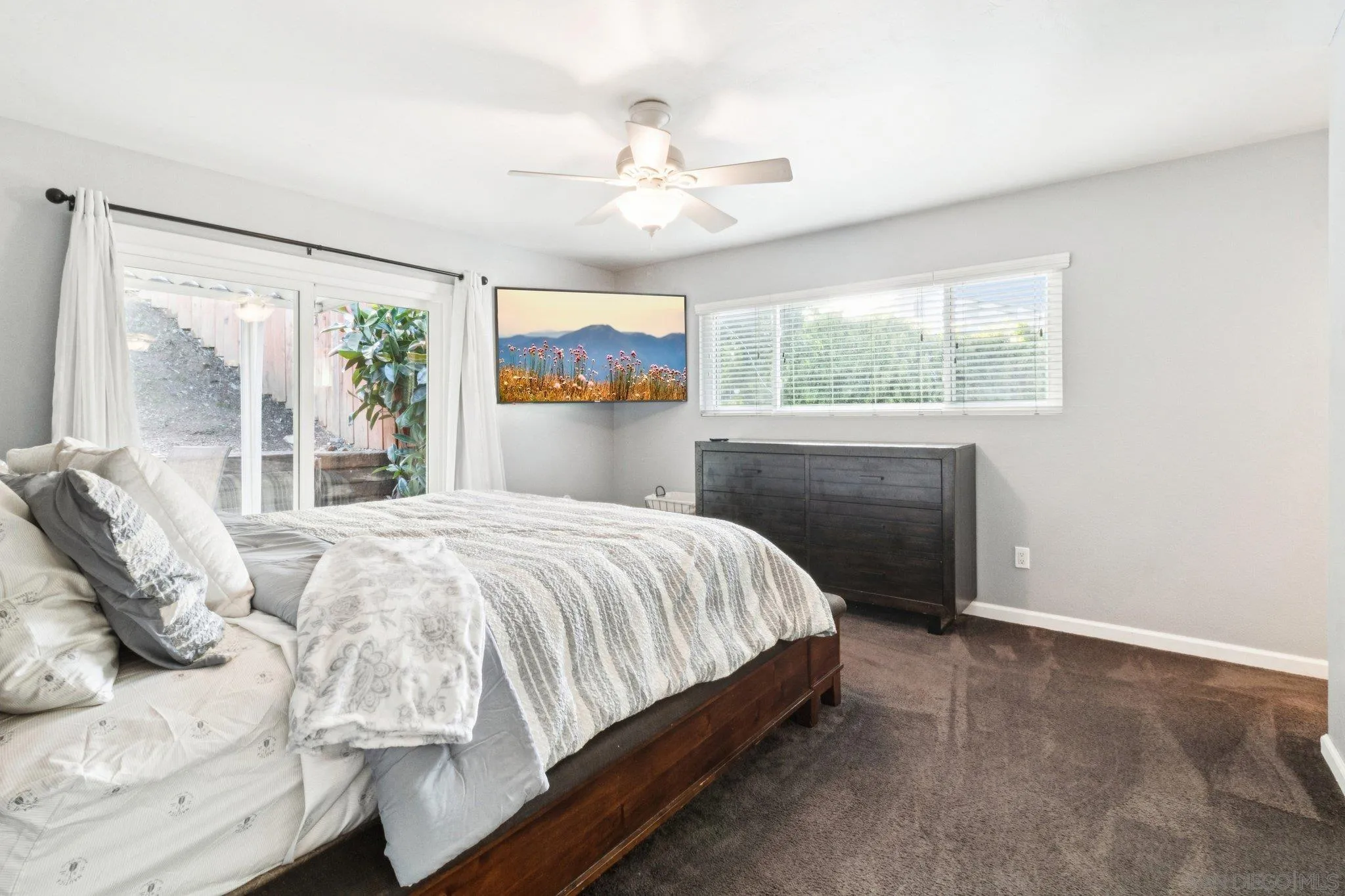 3365 South Bonita Street Spring Valley, CA 91977 - Photo 22 of 32 a bedroom with a large bed and a chandelier