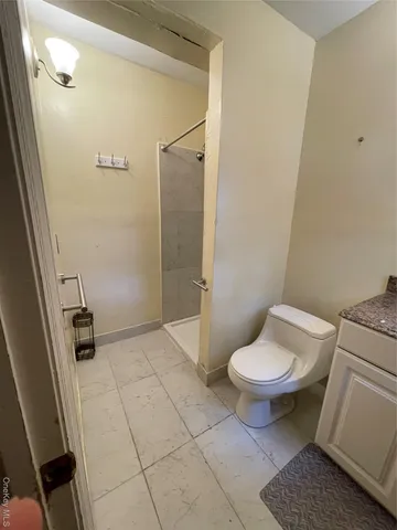 a bathroom with a toilet and a shower