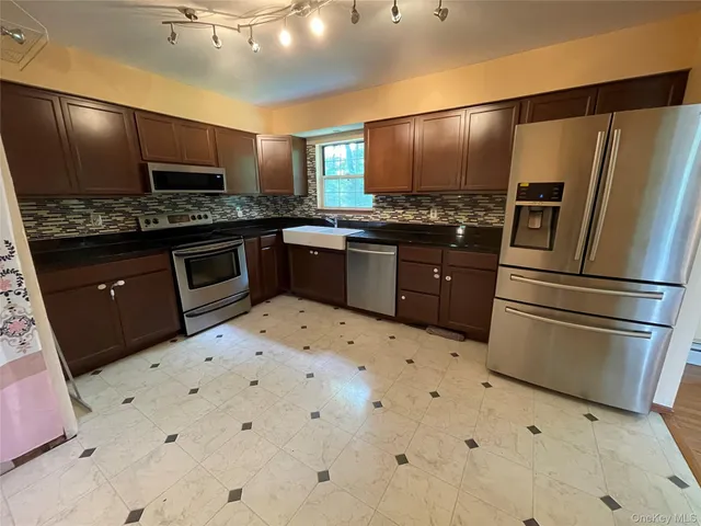 a kitchen with granite countertop a refrigerator and a stove