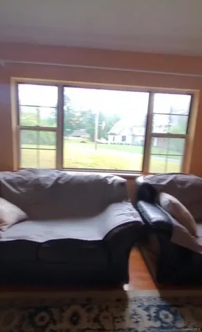 a living room with a bed and a large window