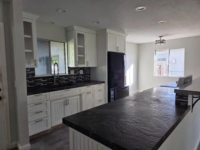 a kitchen with a refrigerator and a stove top oven