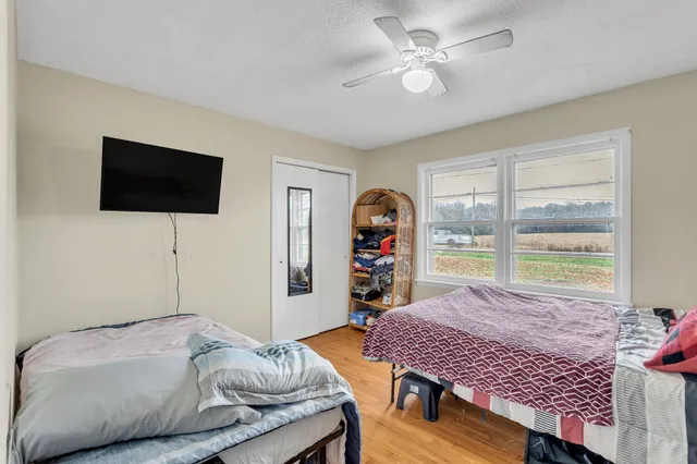 a bedroom with a bed a window and a flat screen television