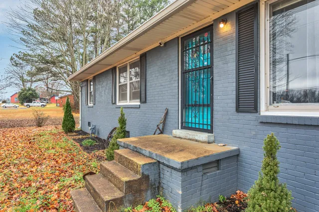a view of house with backyard and sitting area