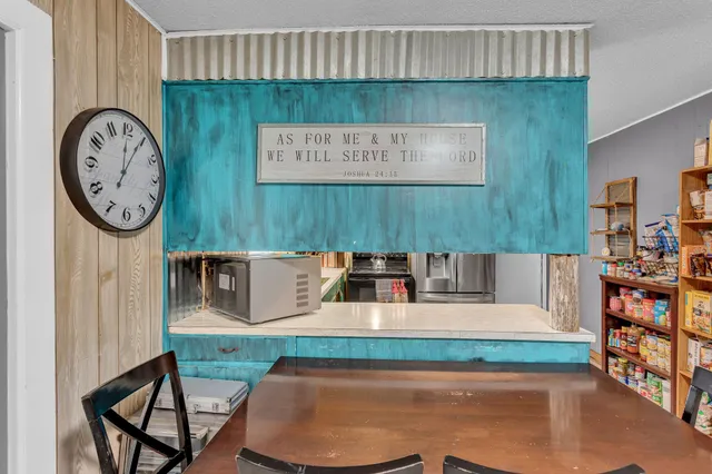 a living room with a clock on wall and a table