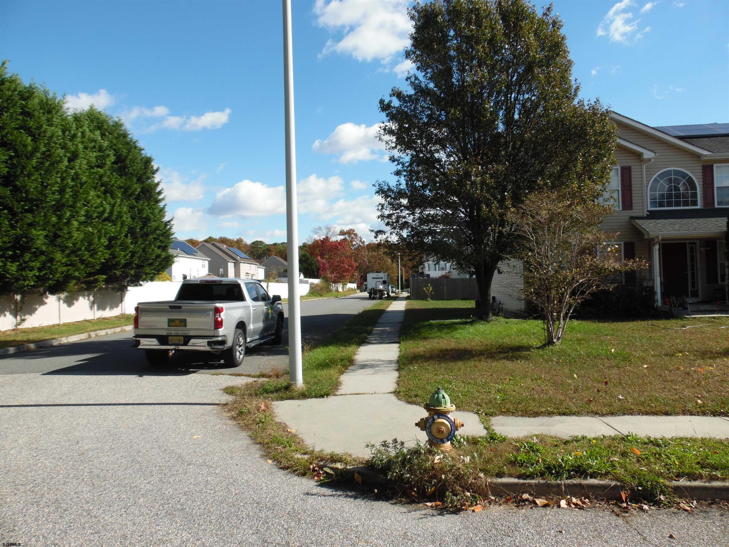 0 South Holly Avenue Galloway Township, NJ 08205 - Photo 8 of 14 a car parked in front of a house next to a yard