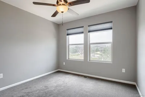 an empty room with a window and a fan