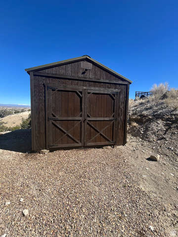 19075 West Honesty Cove Duchesne, UT 84021 - Photo 28 of 44 Wood-sided storage shed featuring double barn doors and a gable roof