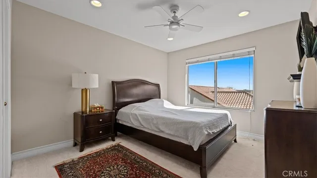 a bedroom with a bed a dresser next to a window