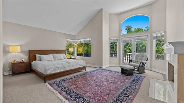 a bedroom with a bed a table and large mirror on the dresser