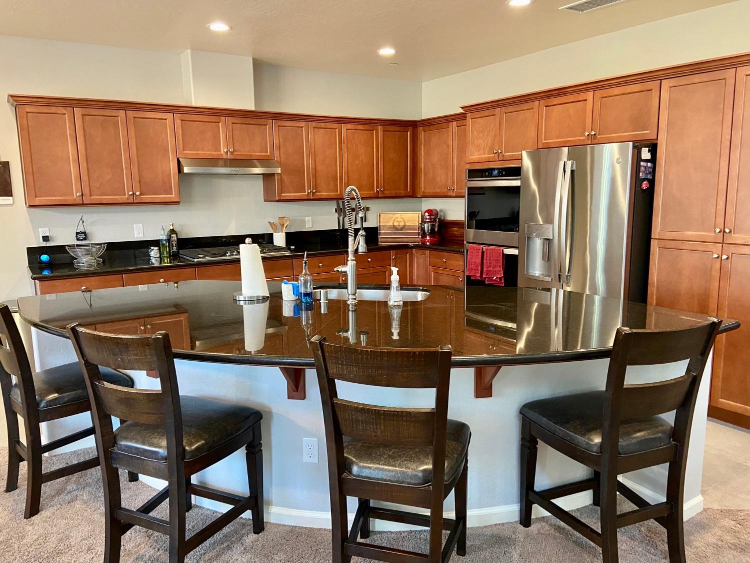 3967 Lincoln Avenue Clovis, CA 93611 - Photo 9 of 70 a kitchen with stainless steel appliances granite countertop a table chairs refrigerator and microwave