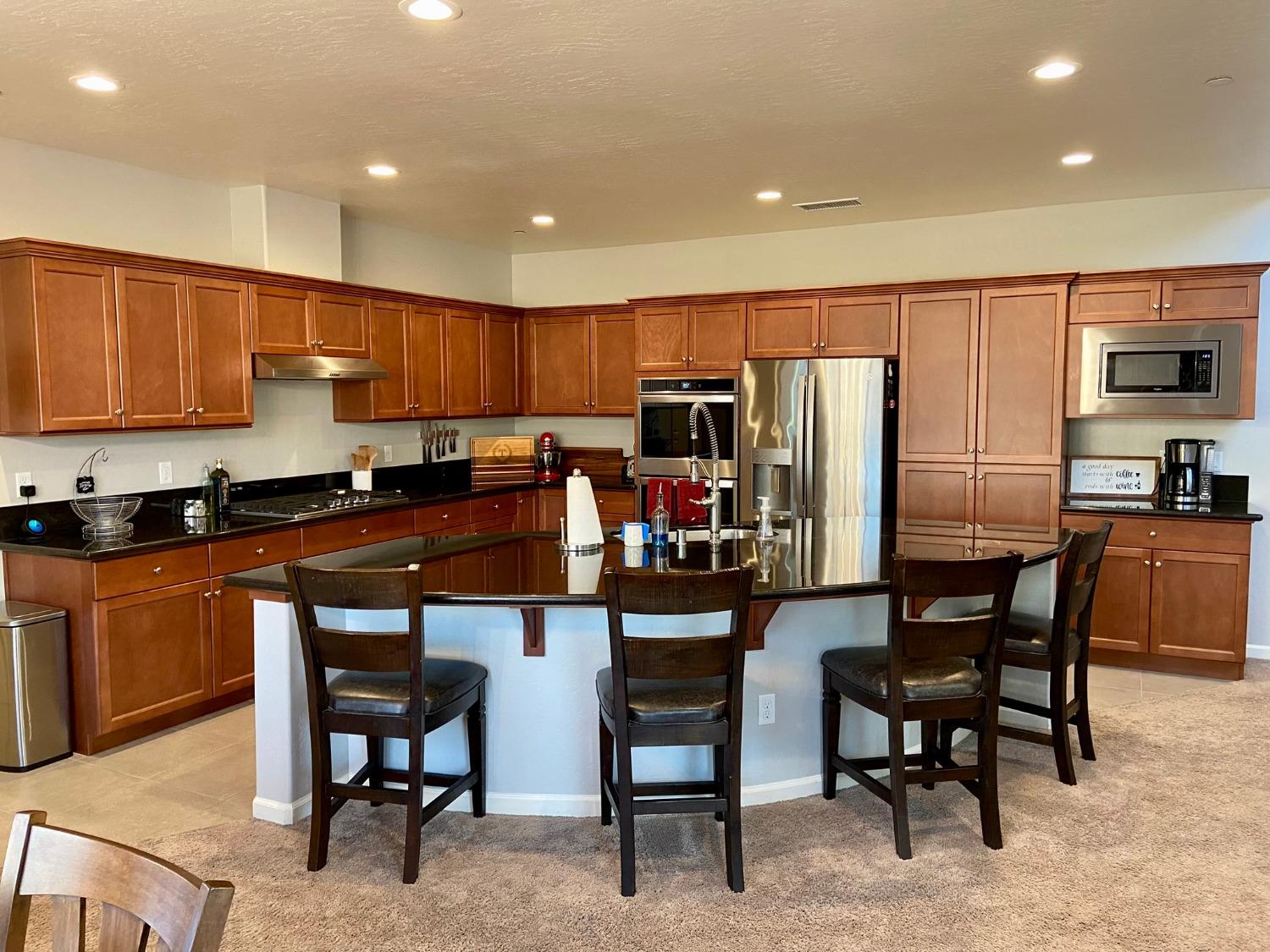 3967 Lincoln Avenue Clovis, CA 93611 - Photo 10 of 70 a kitchen with stainless steel appliances kitchen island granite countertop a table chairs microwave and sink