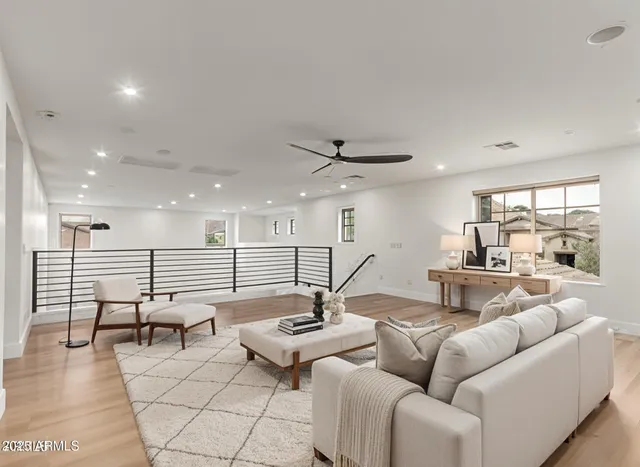 a living room with couches and kitchen view with wooden floor