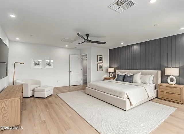 a bedroom with a large bed and a chandelier
