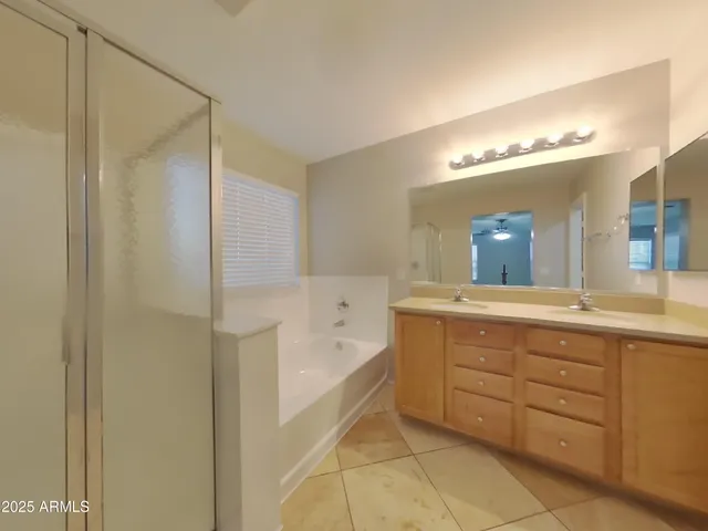 a spacious bathroom with a tub shower and sink