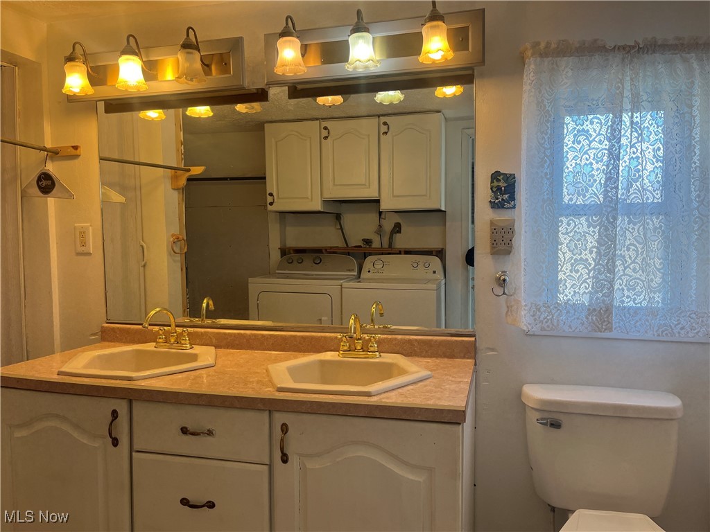 57894 Flamingo Road Senecaville, OH 43780 - Photo 14 of 20 Full bath with double vanity, separate washer and dryer, toilet, and a sink