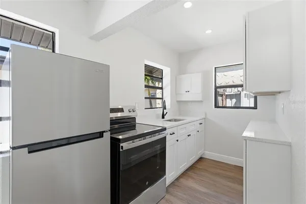 a kitchen with a refrigerator and a stove top oven